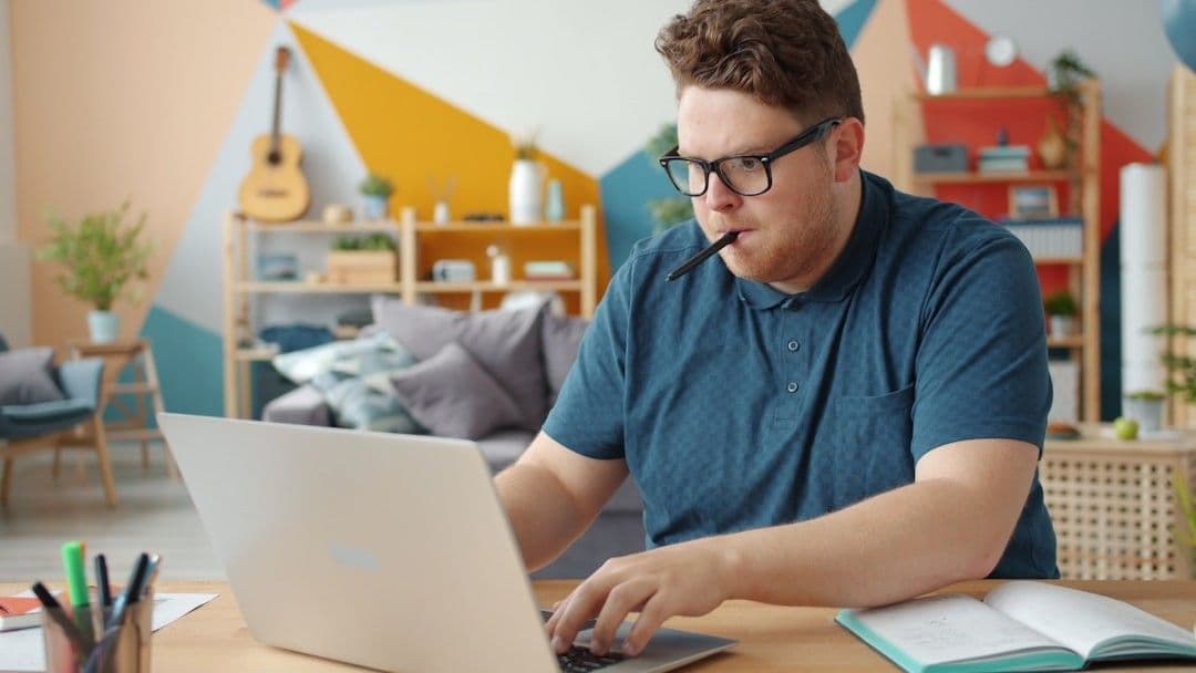 Man working on a laptop at a desk.