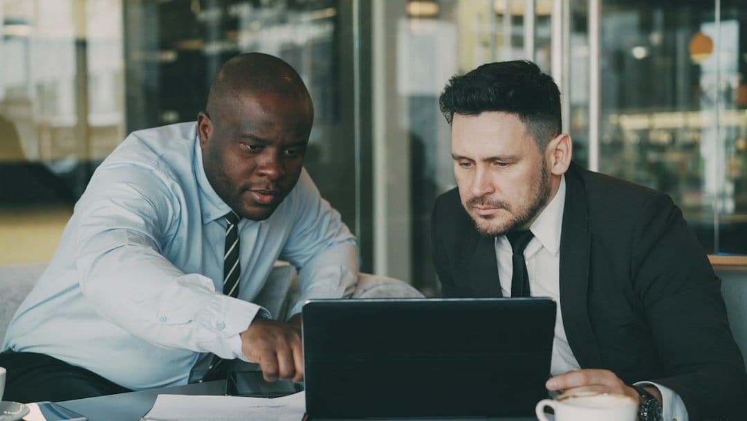 Two men looking at a laptop together