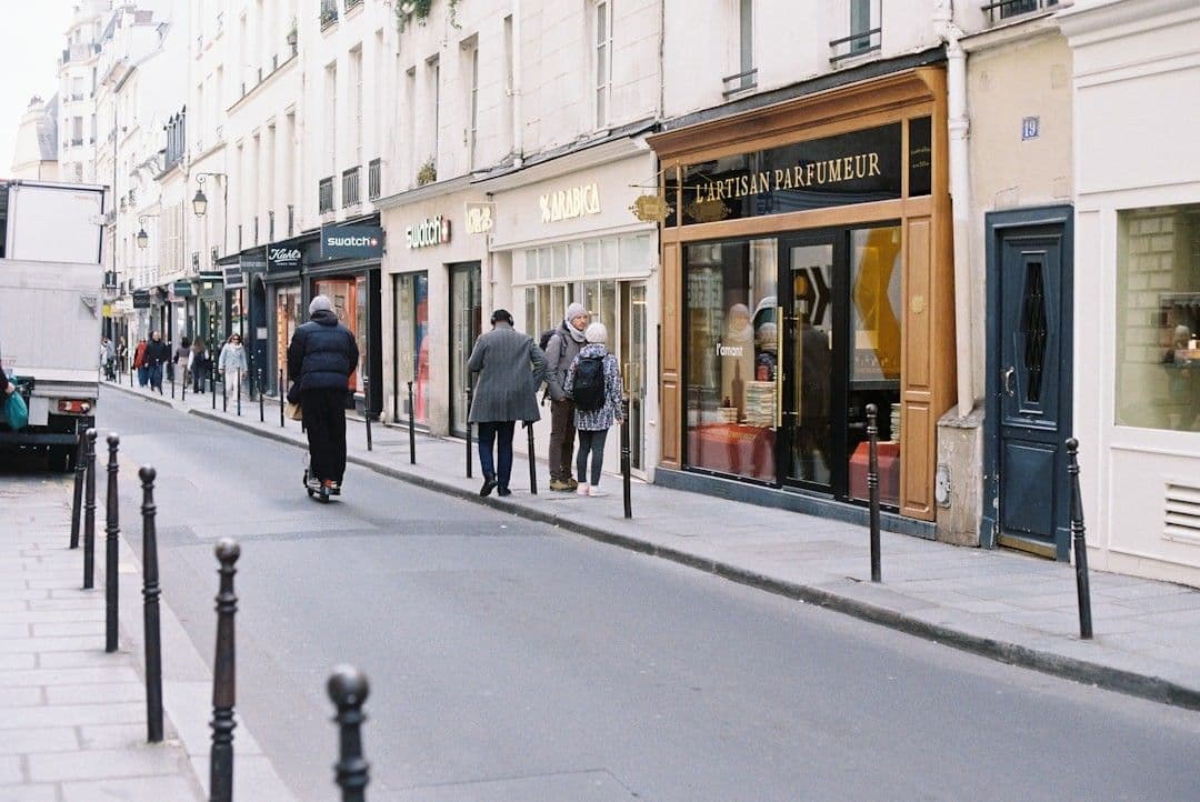 People walking down a parisian street with shops.