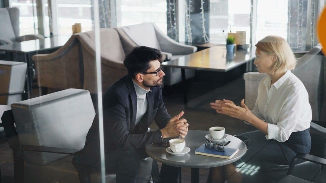 a man and a woman sitting at a table talking