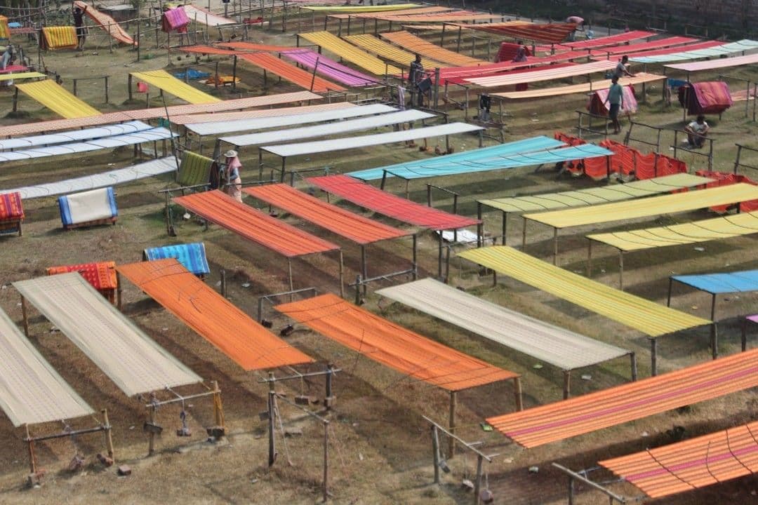 a group of people standing around a bunch of beds