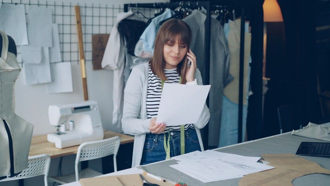 A seamstress talks on the phone in her studio.