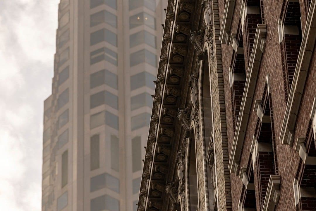 Modern skyscraper behind ornate brick building facade