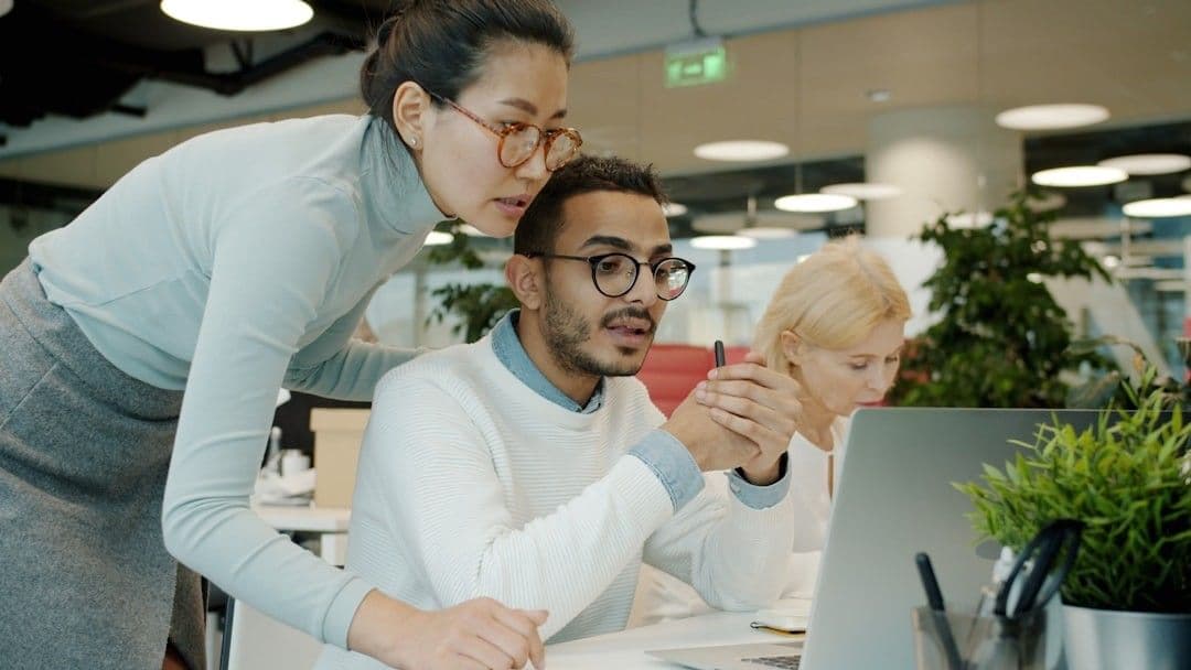 Two colleagues collaborating on a computer screen.