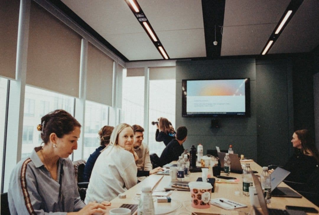 a group of people sitting at a long table