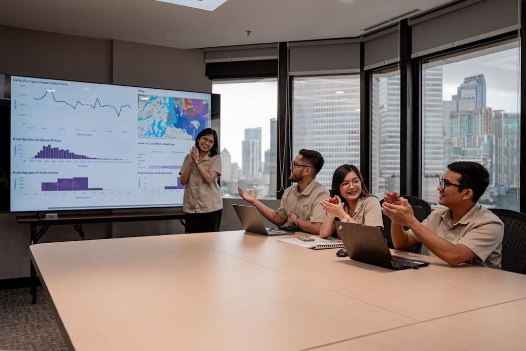 Team collaborates during a business presentation with data on screen.