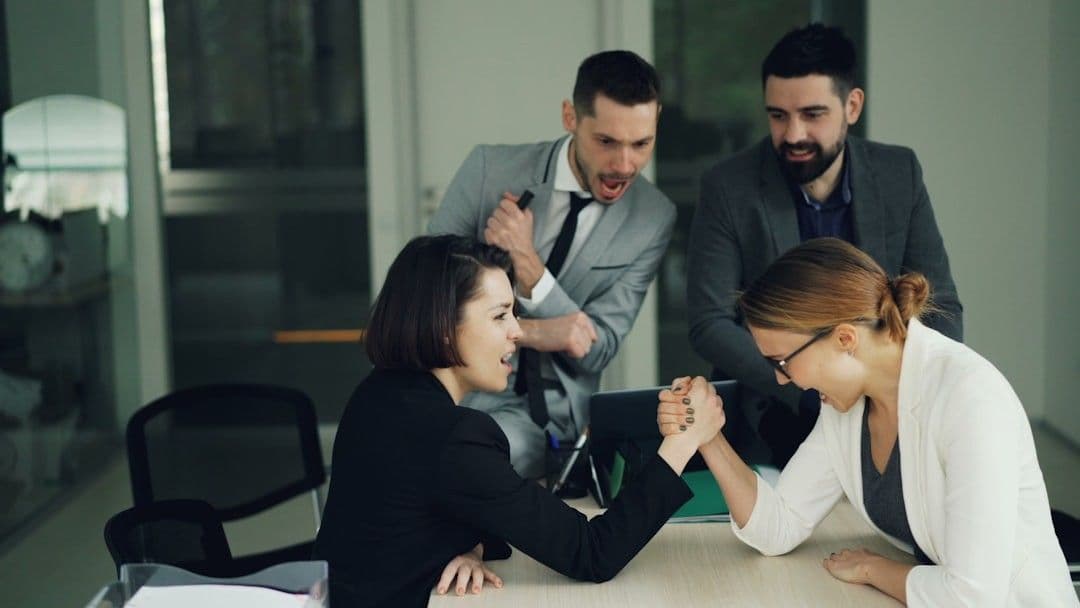 Two women arm wrestling at a table