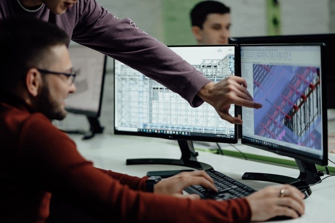 Colleagues collaborate while examining computer designs.