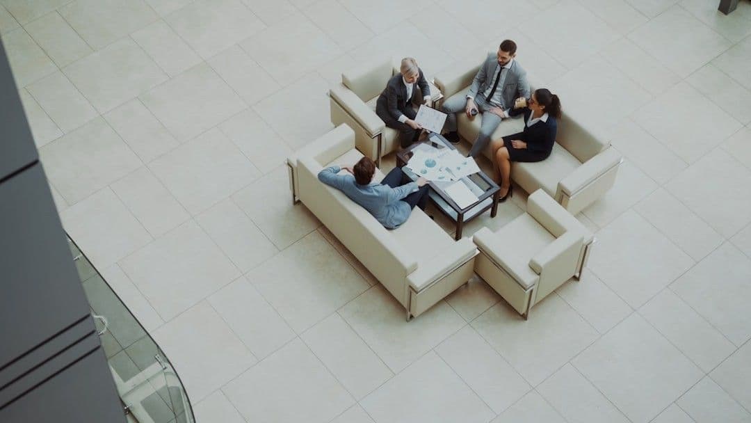 Business people meeting on sofas in a modern lobby.
