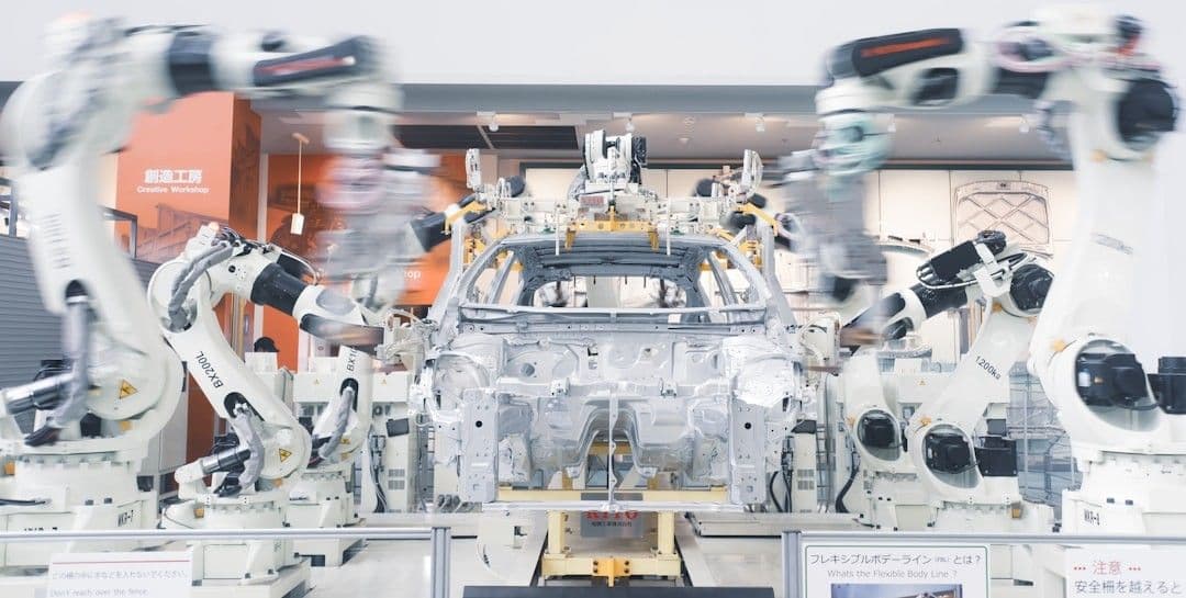 Robotic arms assembling a car chassis on a factory line.