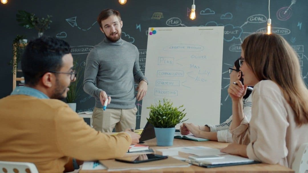 Team collaborating around a whiteboard during a meeting.