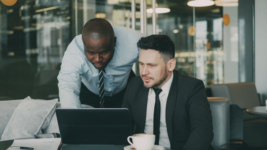 Two businessmen collaborating on a laptop
